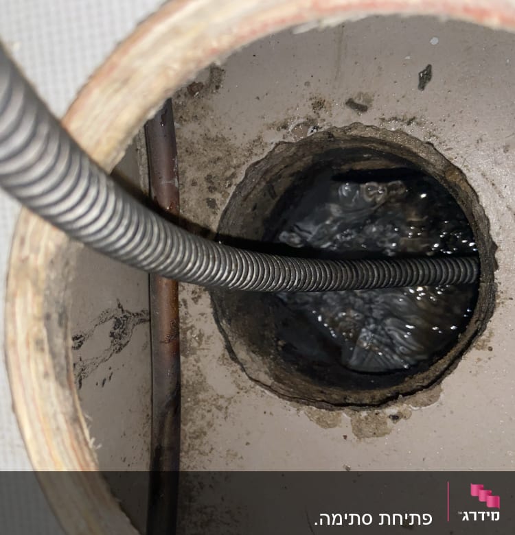 צינור מתכת גמיש בתוך צינור ביוב עם מים